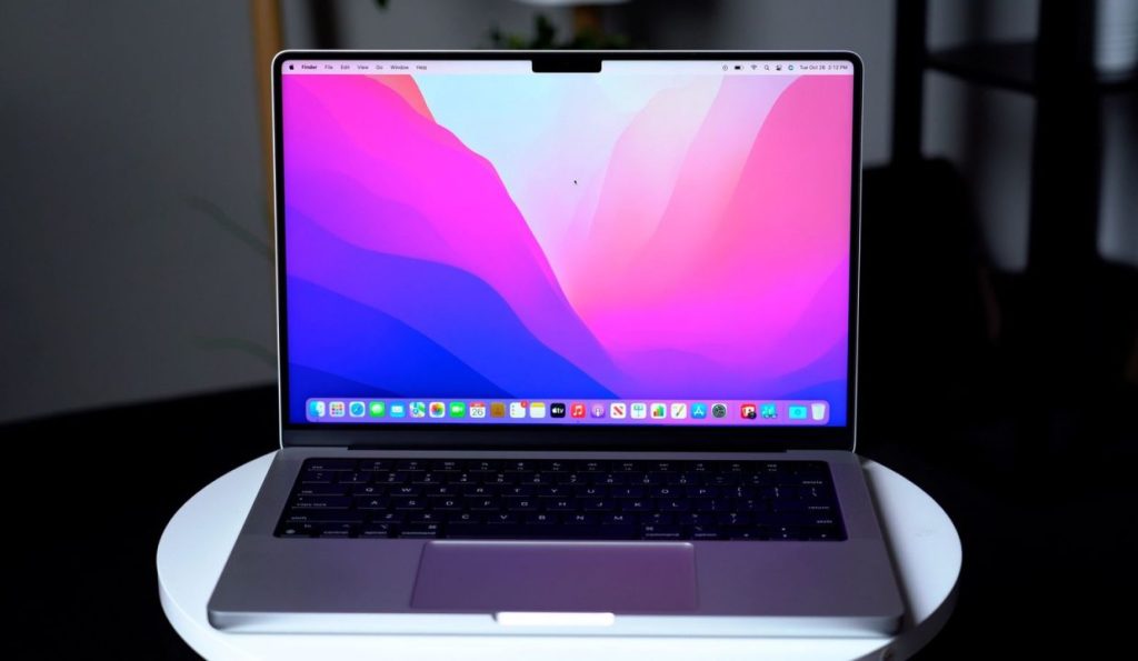 a silver macbook open with the default wallpaper showing